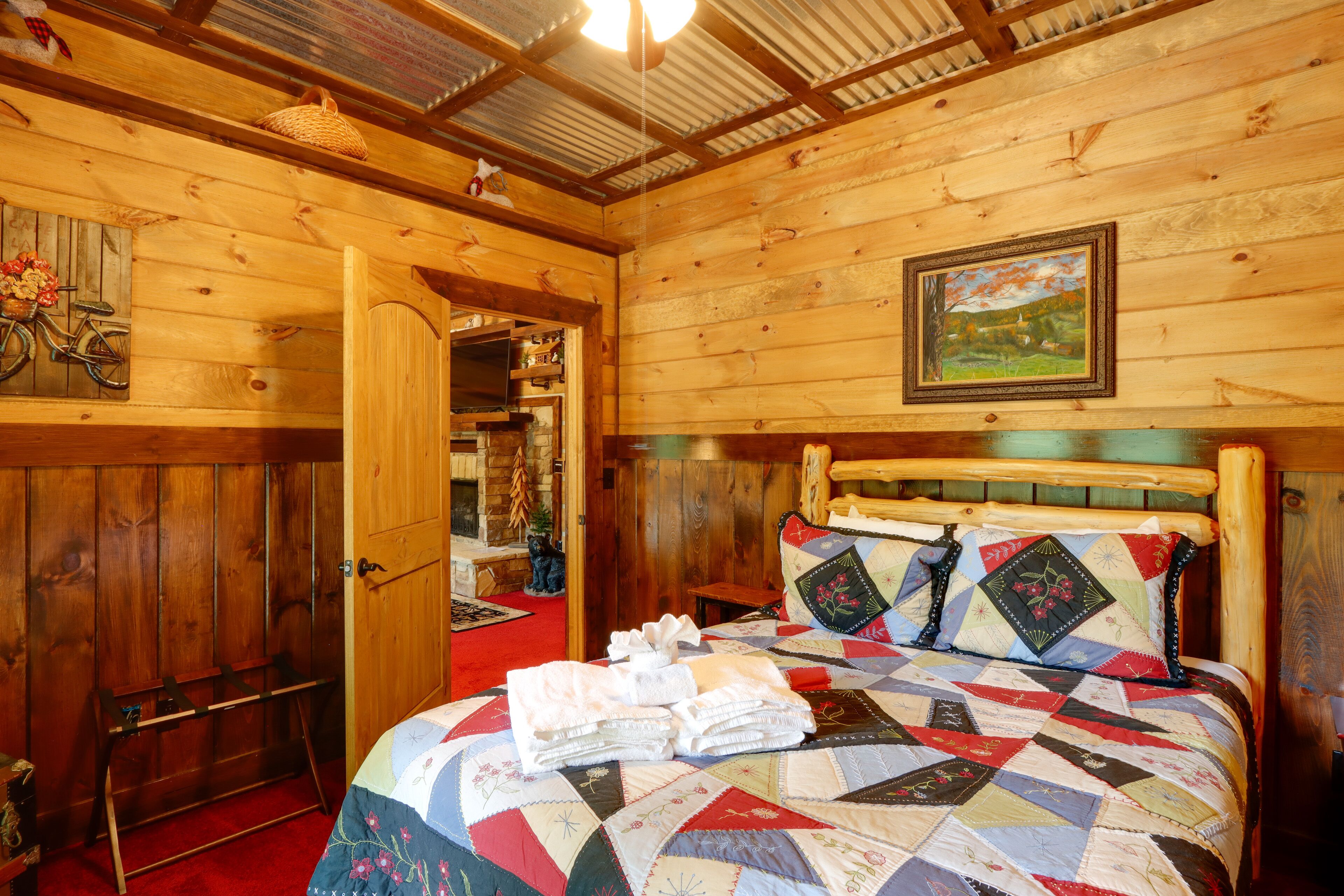 Ein Zimmer in einer Holzhütte mit einem Bett, einer Holztür und einem Bild an der Wand.
