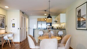 A modern kitchen with wooden cabinets, a central island, and pendant lighting. - w* | Remarkable 1BR with Balcony in Miraflores (Miraflores)