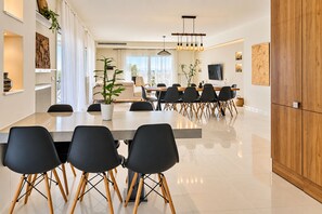 Un espace de restauration moderne avec une longue table, des chaises noires et une plante en pot.
