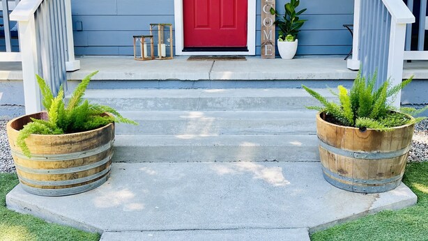 A red door with a wreath, two wooden lanterns, a welcome sign, and two wooden planters with greenery on a porch. - Close to Montgomery Village and Flamingo Resort, just minutes to wineries (Santa Rosa)