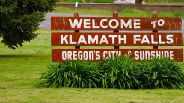 Willkommensschild für Klamath Falls, Oregon, Stadt und Sonnenschein.