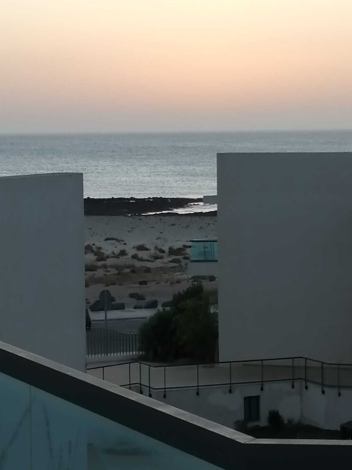 Blick auf einen Strand, im Vordergrund ein Gebäude.