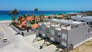 Un bâtiment moderne doté d’un toit plat, de grandes fenêtres et offrant une vue sur l’océan.