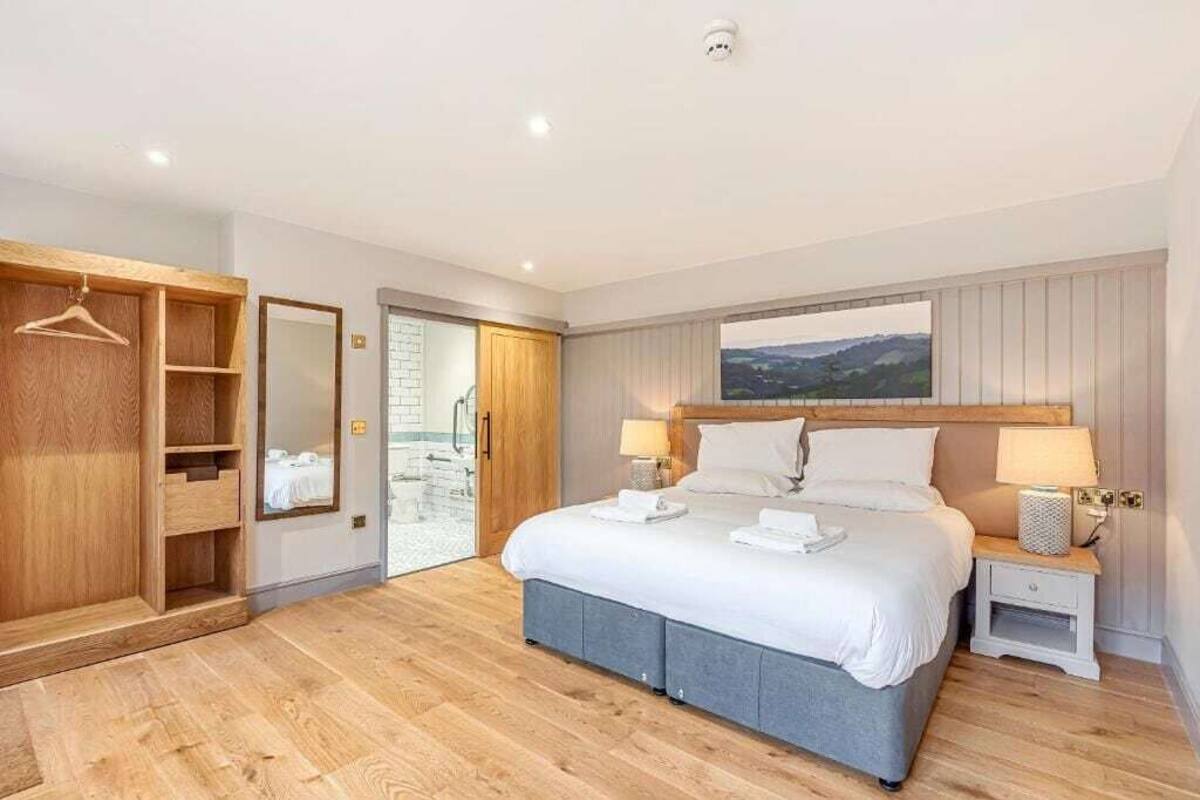 Un dormitorio con cama, mesitas de noche, armario y vistas al exterior.