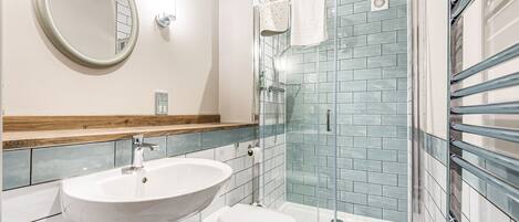 A bathroom with a sink, toilet, and glass-enclosed shower.