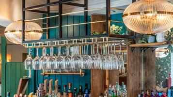 A bar area with multiple bottles and glasses.