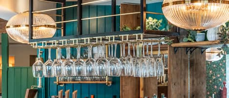 Un espace bar avec de nombreuses bouteilles et des verres.