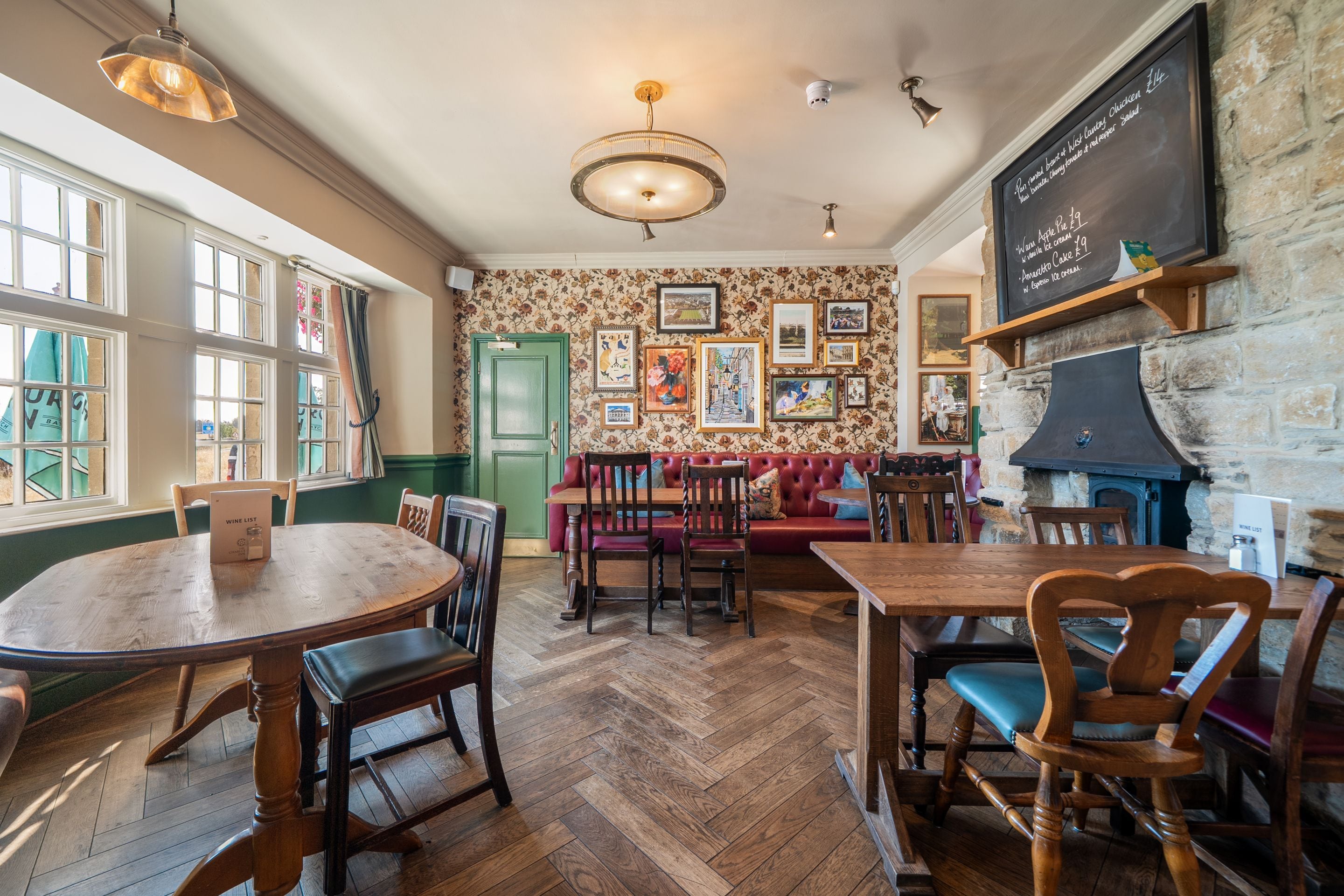 Een restaurant interieur met houten meubels, een visgraatvloer en een krijtbordmenu.