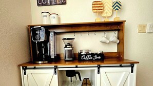 A coffee station with a coffee maker, tea dispenser, and a coffee bar sign. - Spectacular panoramic views on nearly 10 acres, Stargazing, Spa, Family Friendly (Twentynine Palms)