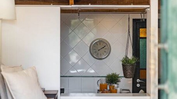 Quarto estilo loft com beliche, pequeno espaço de cozinha e área de refeições.