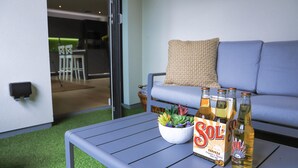 A modern living room with a grey sofa, a coffee table with a bottle of Sol beer, a bowl of succulents, and a small potted plant. - Apartment Seven (Shrewsbury)