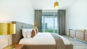 A modern hotel room with a large bed, a nightstand, a dresser, and a view of the city through large windows. - Maison Privee - Superb 1BR apartment overlooking Zabeel Park and Dubai Frame (Dubai)