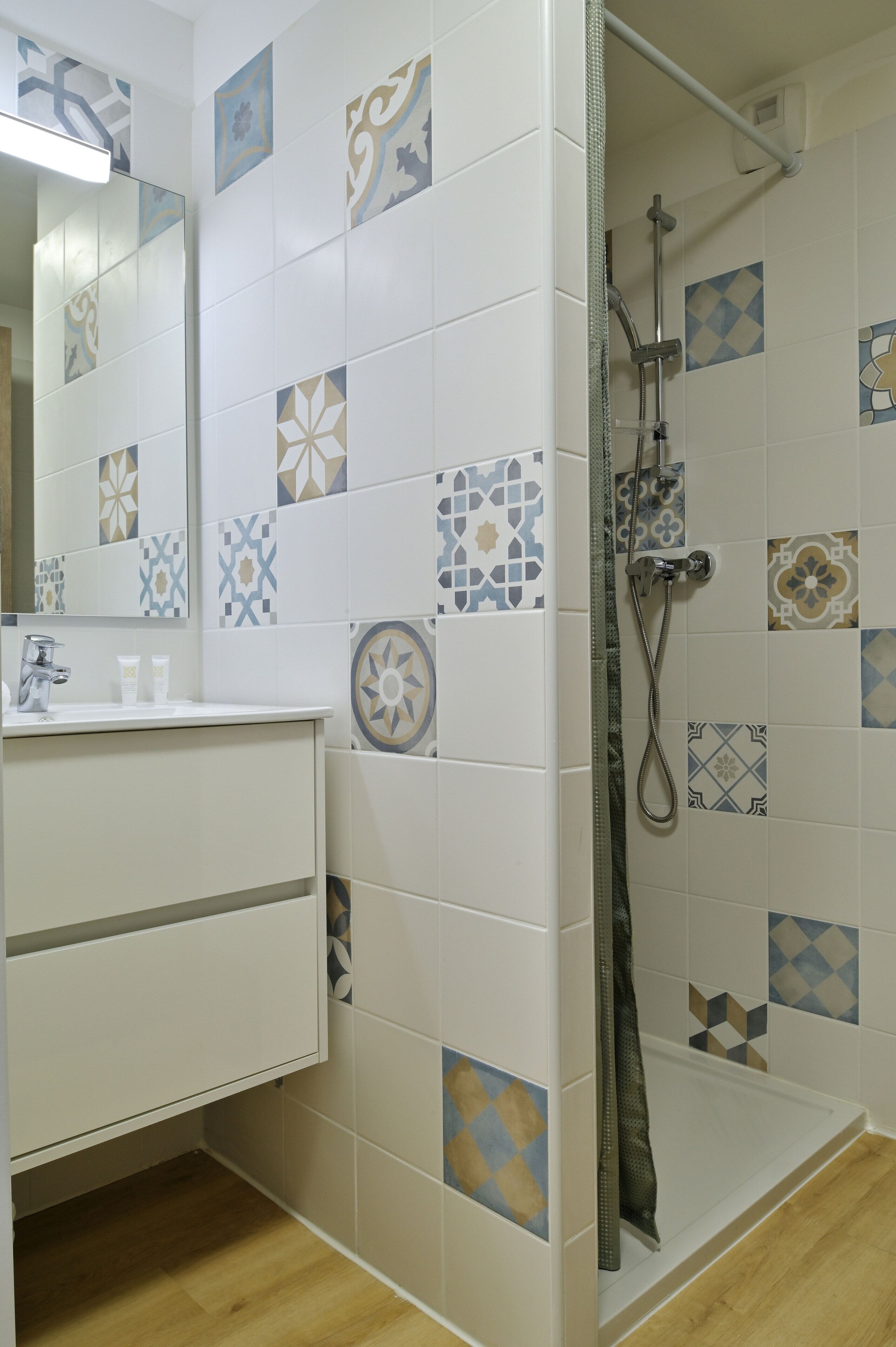 Un baño con ducha, lavamanos y espejo.