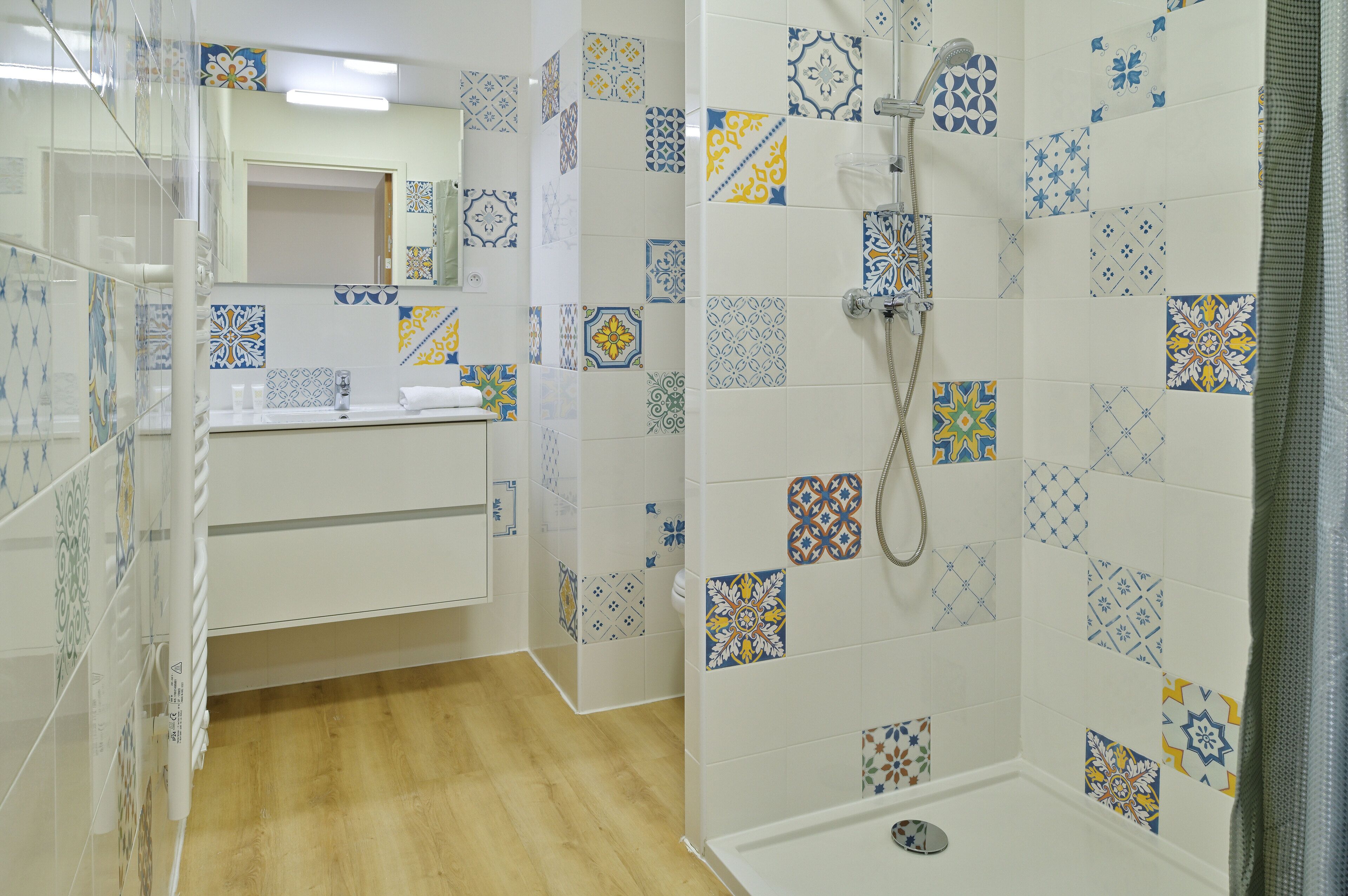 A bathroom with a shower, a sink, and a mirror.