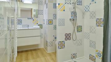 A bathroom with a shower, a sink, and a mirror.