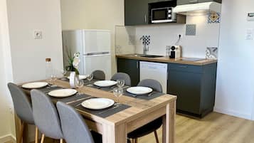 Superior appartement | Privékeuken | Een koelkast met diepvriezer, een microgolfoven, een kookplaat