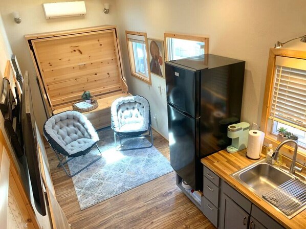 A compact kitchen with a black refrigerator, wooden cabinets, and a sink. - San Luis Obispo Sunshine Tiny Home with 2 Queens (San Luis Obispo)