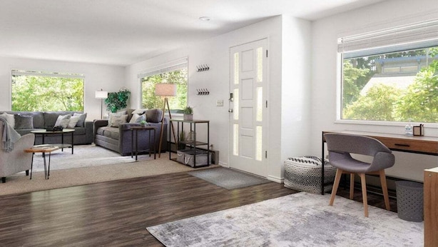 A modern living room with a sofa, coffee table, and a desk area with a chair. There is a large window providing a view of greenery outside. - Perch - Island Hideaway in Historic Nature Reserve (Coupeville)