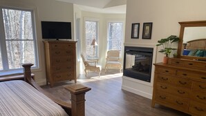 A bedroom with a bed, wooden dresser, TV, fireplace, and large windows. - 5-acres, Large 5-Bedroom Home with possible 6th Nursery next to Master Bedroom. (Morrow)
