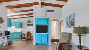 A spacious living area with a kitchen, teal cabinets, a beige sofa, and a dining table with chairs. - Welcome to Siesta Dreams at Casa Mar!! (Siesta Key)
