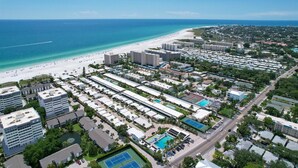 An aerial view of a coastal resort area with beachfront hotels, a sandy beach, and a large pool complex. - Welcome to Siesta Dreams at Casa Mar!! (Siesta Key)