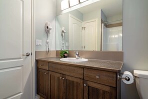 Bathtub, hair dryer, towels, shampoo