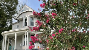 A two-story house with a porch and a garden.