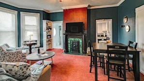 Ein Wohnzimmer mit Kamin, Essbereich und Deckenventilator.