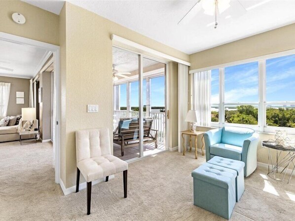 Relax in a spacious living room with a comfortable seating area featuring a sofa, ottoman, and armchair.