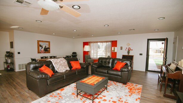 A living room with a sectional sofa, a coffee table, and a dining area in the background. - The Ranch Near Boomer Lake (Stillwater)