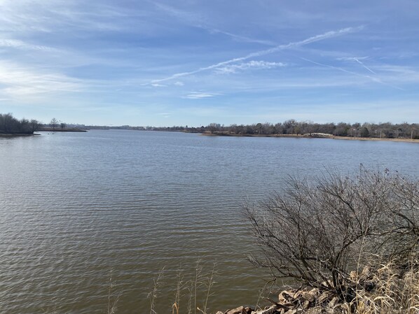 A river with calm water, trees, and a clear sky.