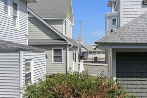 A residential street with houses, a utility pole, and a clear sky. - Whale's Tale - Boutique Studio Condo w/Pool 🐳 (Hampton)
