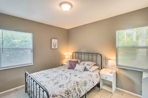 A bedroom with a bed, bedside tables, and a ceiling light.