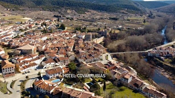 An aerial view of a town with a river, surrounded by hills. - Hotel Rural Covarrubias (Covarrubias)