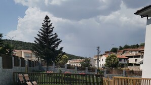 Une piscine rectangulaire à l’eau d’un bleu limpide, entourée d’une clôture en bois et d’un mur de pierre.