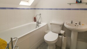 Un baño con bañera, inodoro y lavamanos.