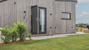 Un bâtiment moderne avec une façade en bois, une porte en verre et une petite fenêtre.