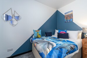 Ein Schlafzimmer mit einem Bett, das eine Haifischdecke hat, einem Stadtbildgemälde an der Wand und herzförmigen Spiegeln.