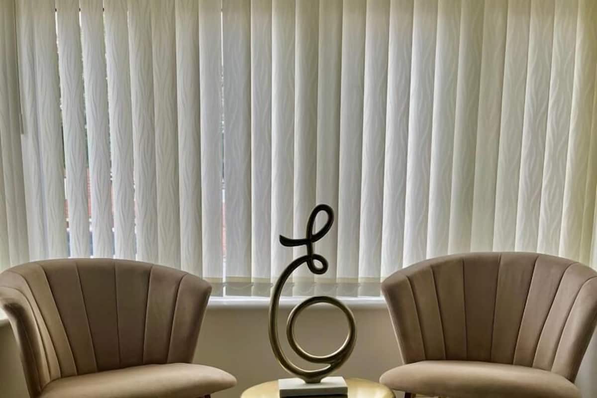 Two armchairs facing each other with a small round table in between, featuring a decorative metal piece.