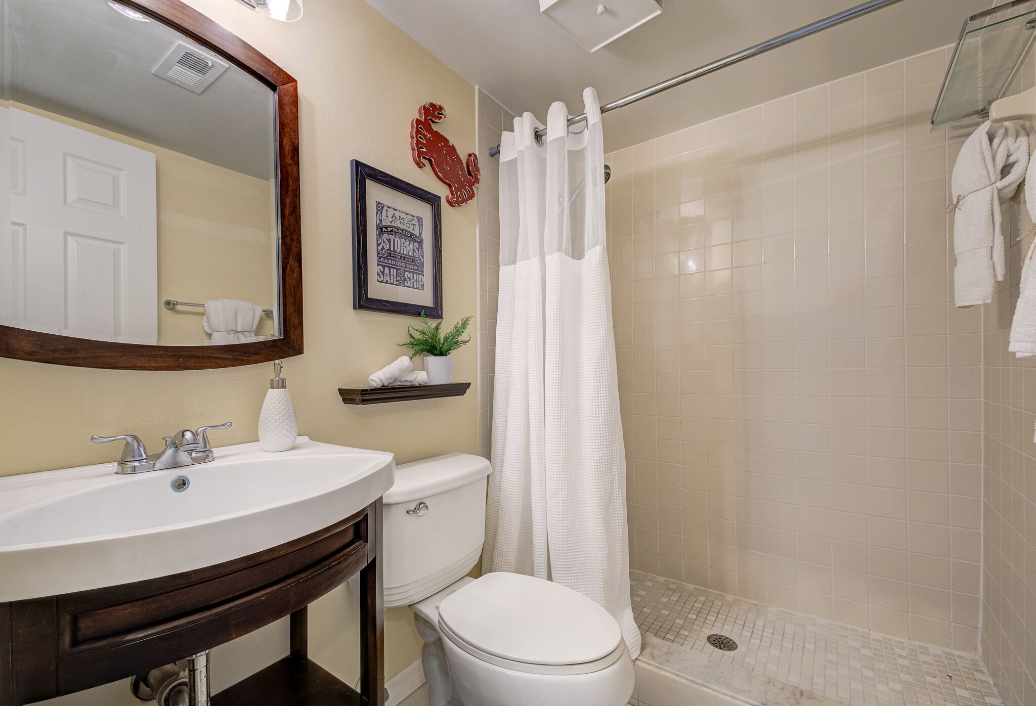 A bathroom with a sink, toilet, and shower.