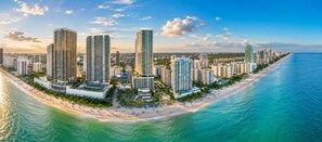 Eine Küstenstadt mit Hochhäusern, einem Strand und einem klaren Himmel.