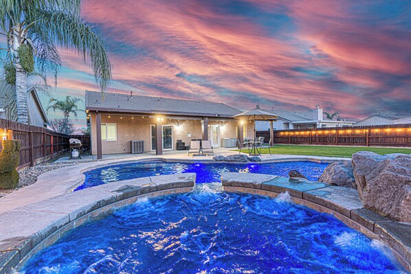A residential property with a swimming pool, a covered patio, and a landscaped yard. - Beautiful Home with Pool & Hot Tub close to National Parks (Selma)