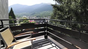 A balcony with a view of a town and mountains.