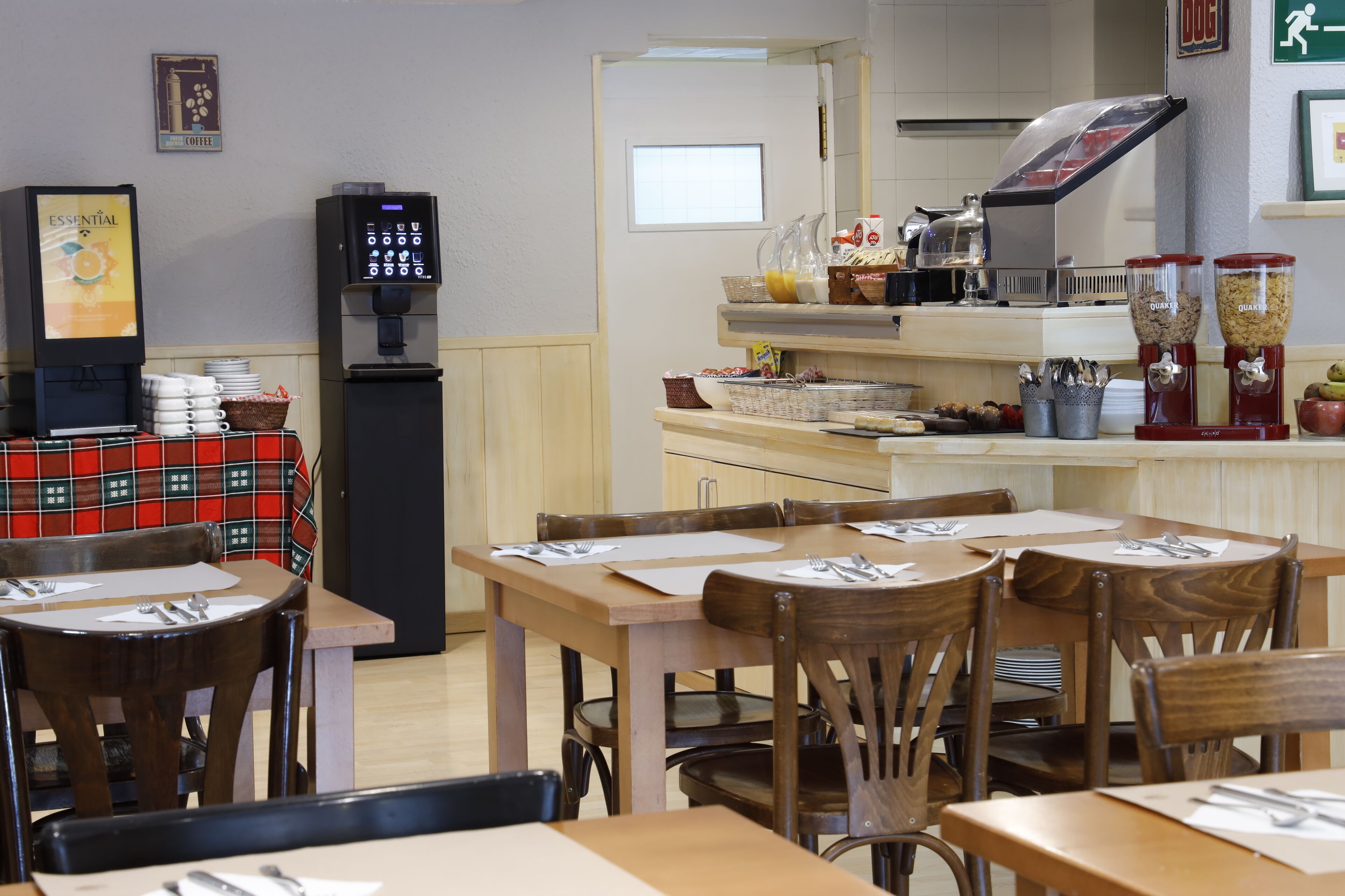 A restaurant with wooden tables and chairs, a coffee machine, and a self-serve beverage station.