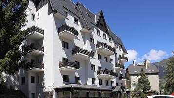 Un hôtel à plusieurs étages, doté de balcons et d’une entrée couverte.