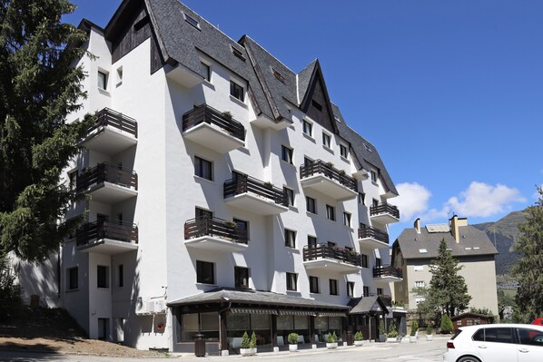 Un hotel de varios pisos con balcones y una entrada cubierta.