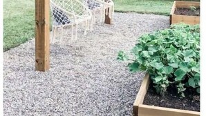 A wooden swing set with two white swings in a garden.