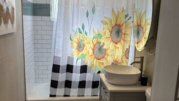 Een bad, milieuvriendelijke toiletartikelen, een haardroger, handdoeken