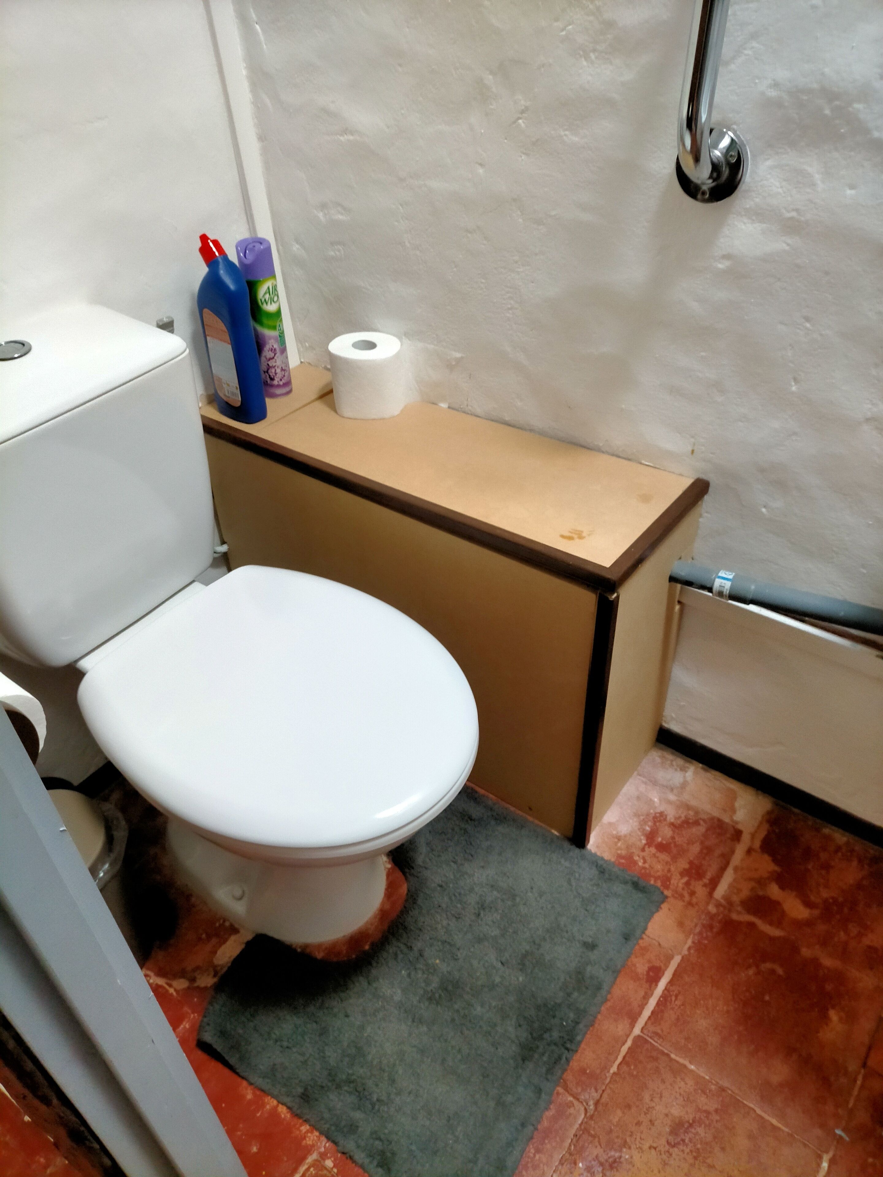 Un baño pequeño con inodoro, lavamanos y ducha.