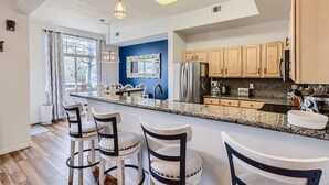 A modern kitchen with a central island, wooden cabinets, and pendant lighting. - Pet Friendly, Spacious Home, Incredible Views, Private Hot tub 152 (Silverthorne)